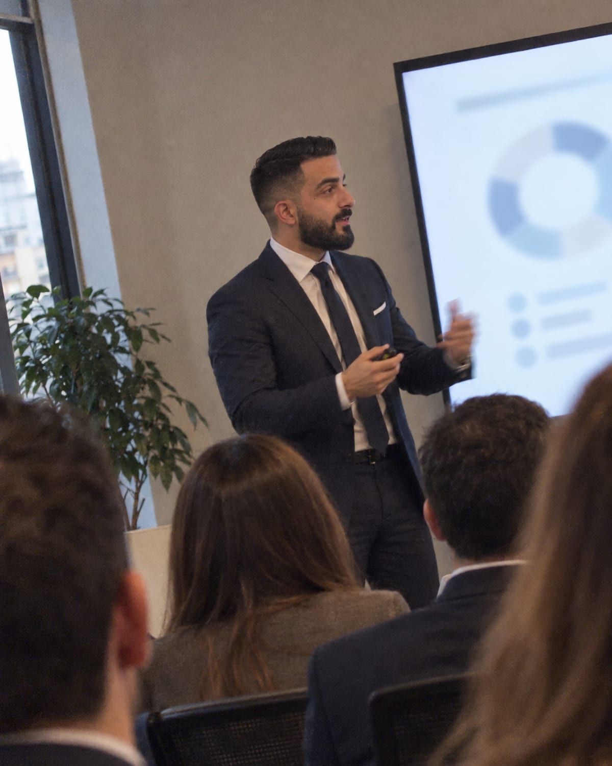 Francesco Sergio presenta un progetto davanti a uno schermo con dei grafici