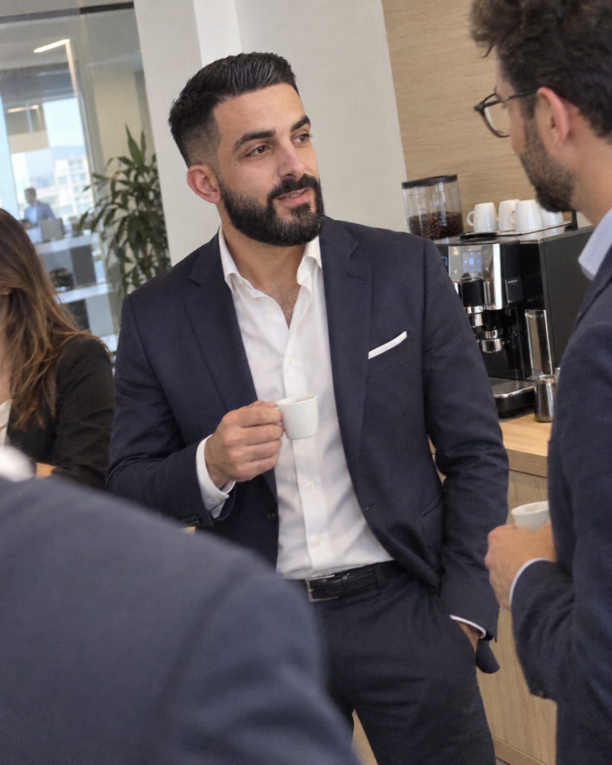 Francesco Sergio in pausa caffè con i colleghi vicino alla macchina del caffè